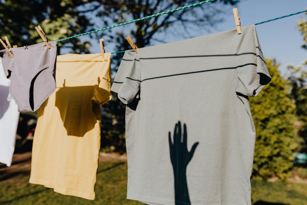 Shadows cast on clothing hanging outside on a sunny day, evoking a sense of fresh and serene rural life.